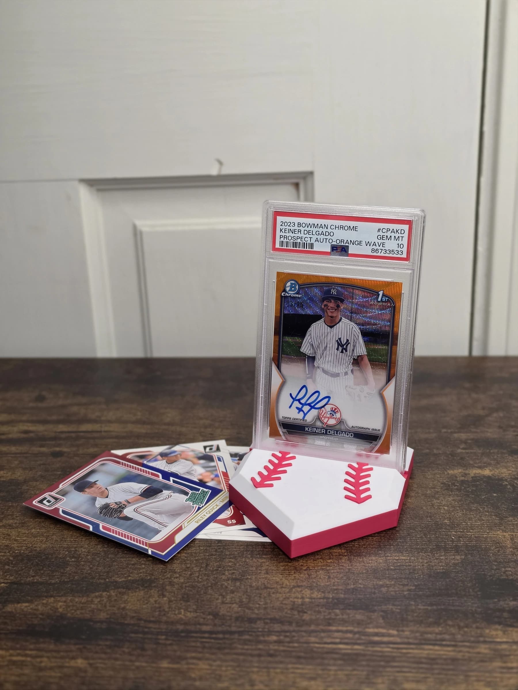 Baseball card stand displaying a graded card beside raw baseball cards