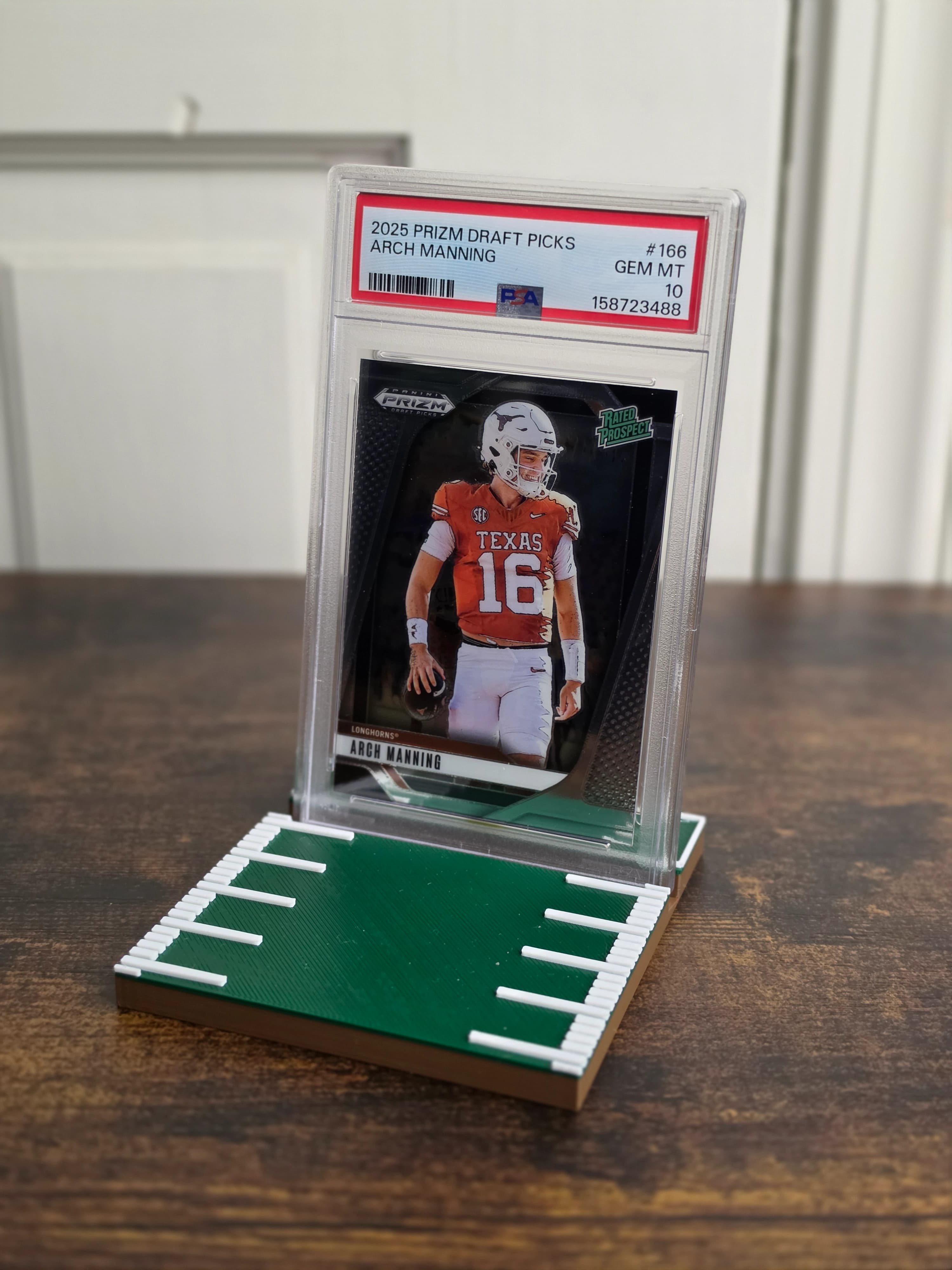 Football field card stand displaying a graded football card